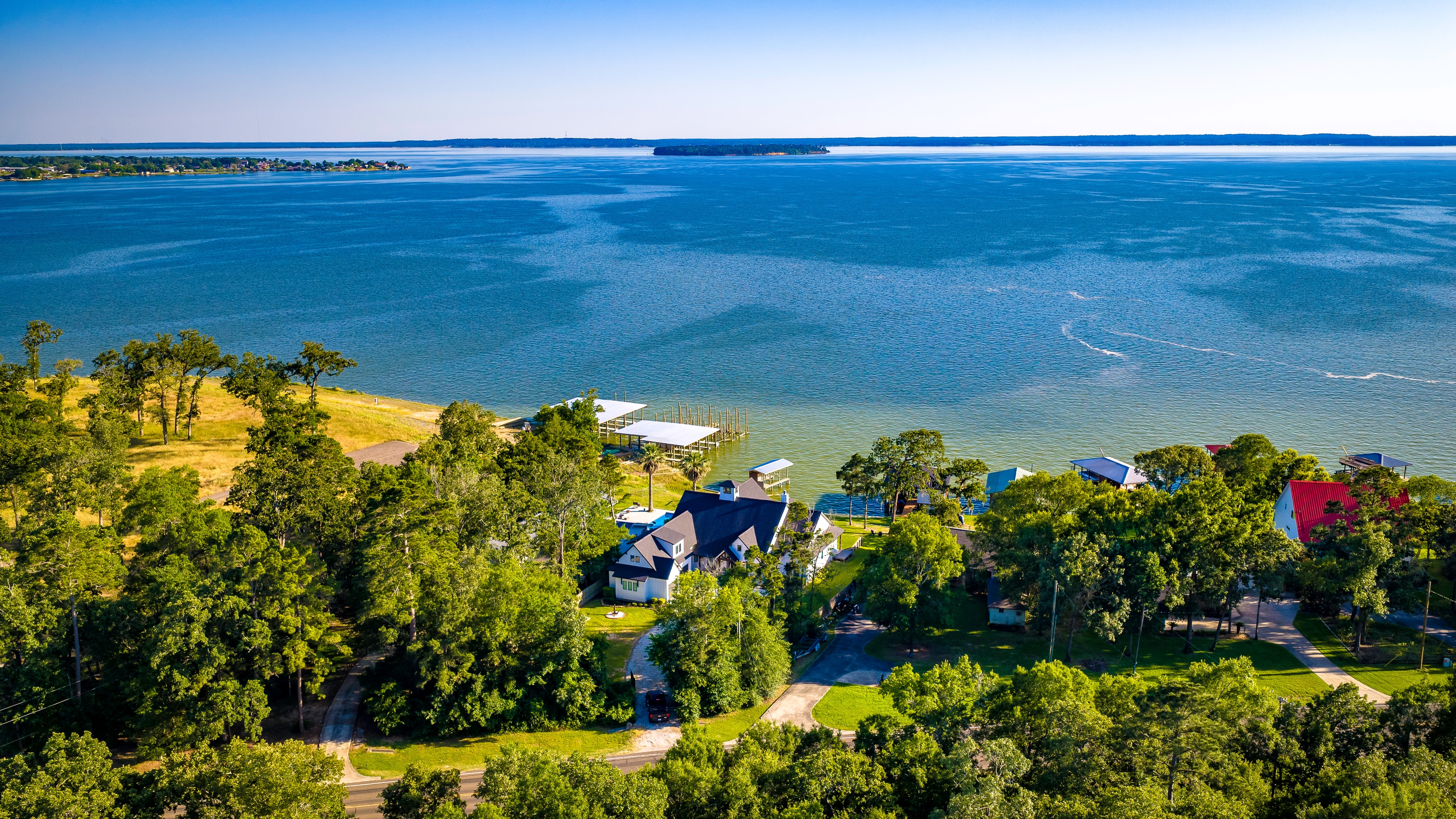 Aerial drone view of lake house and shoreline