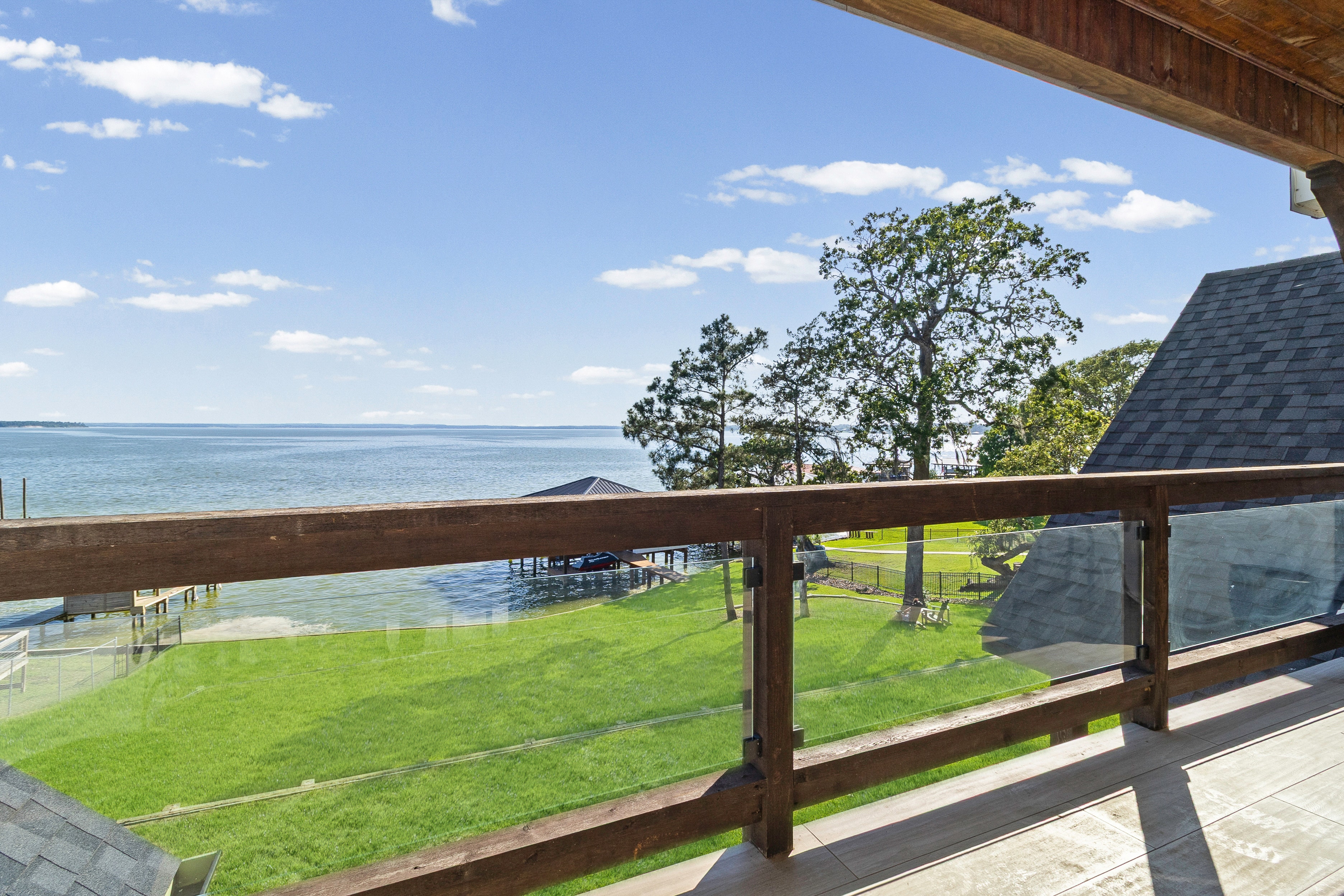 Waterfront deck overlooking lake and lawn
