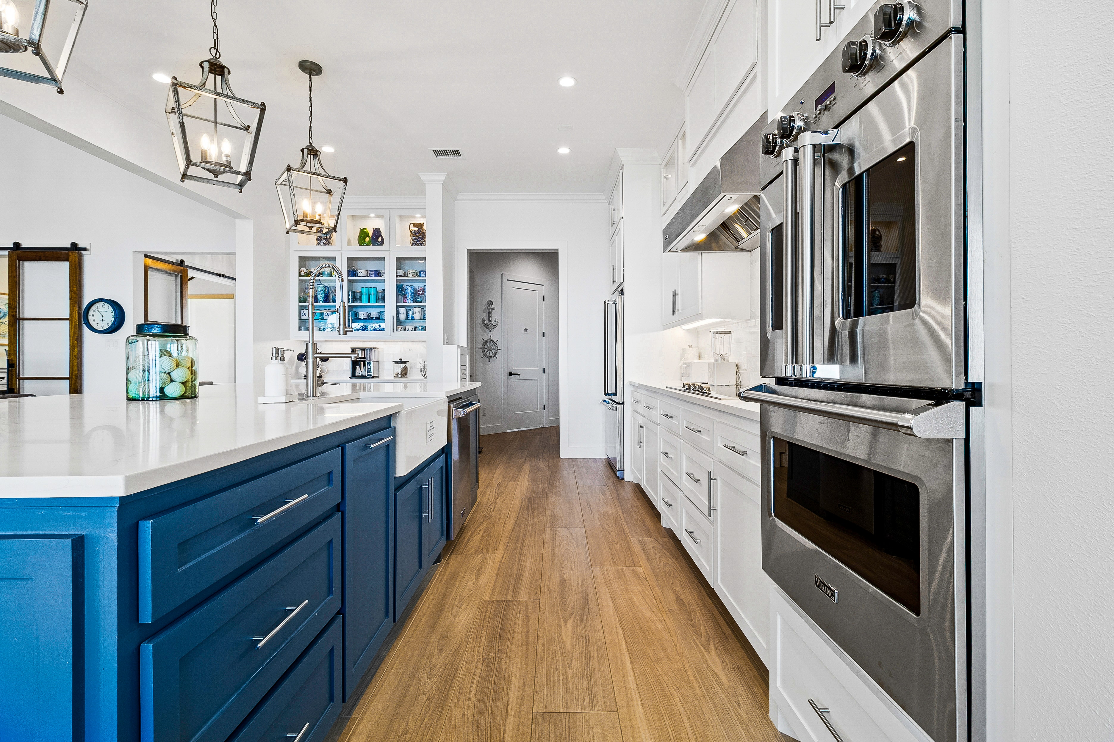 Kitchen with blue island and white cabinetry
