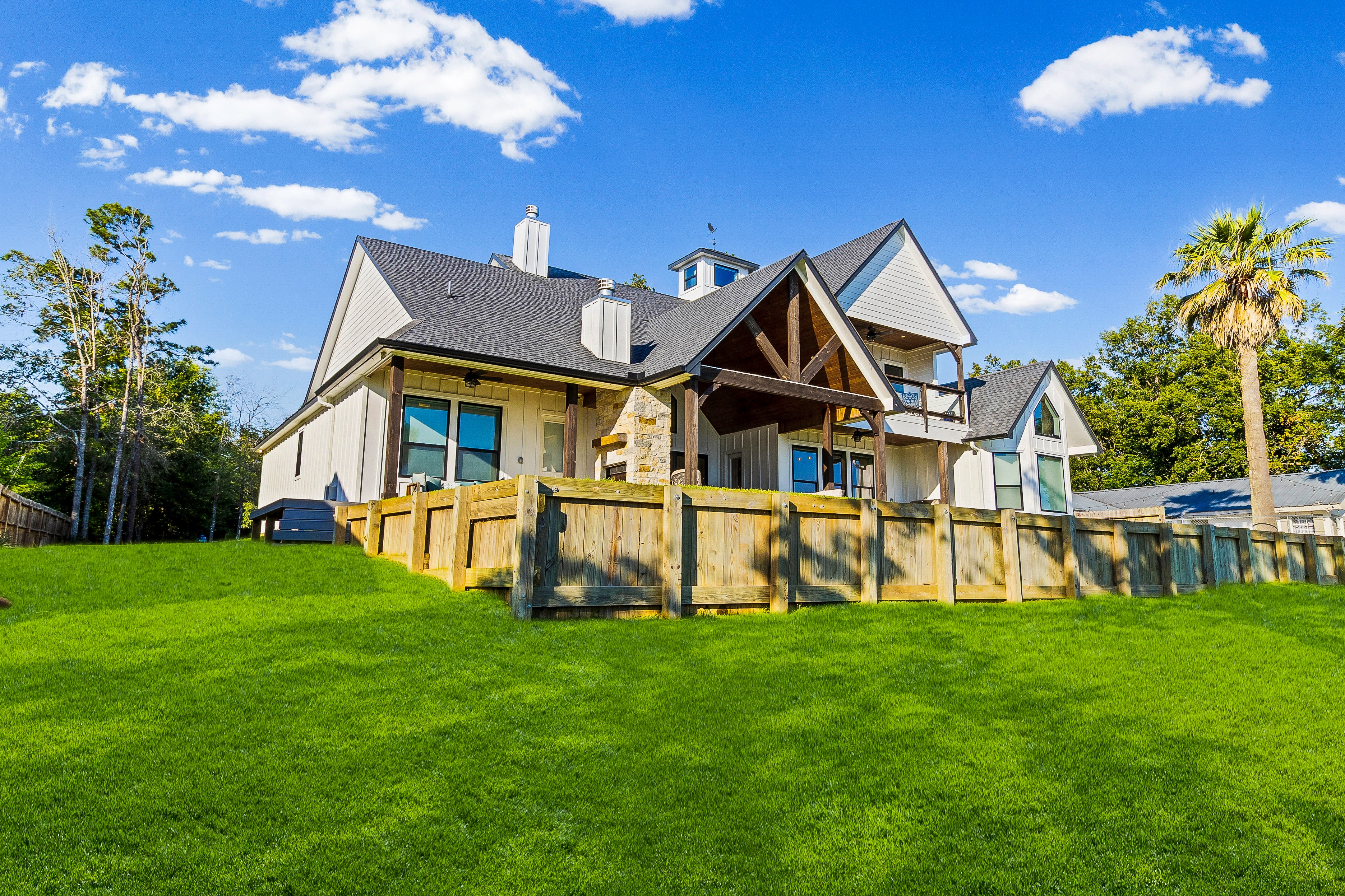 Farmhouse with wooden deck and lawn